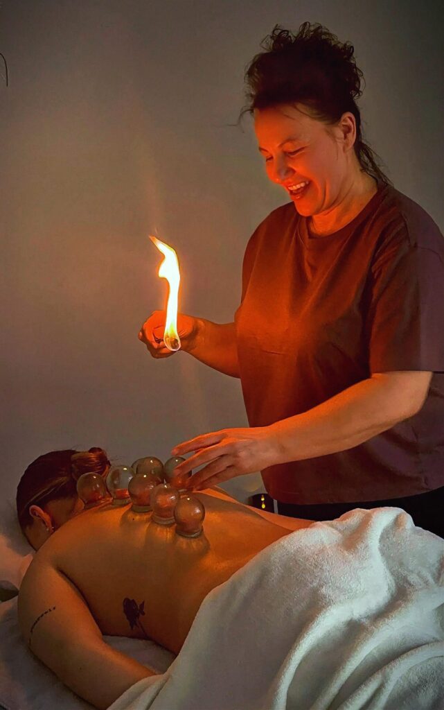 Nina Kostuk performing fire cupping therapy treatment